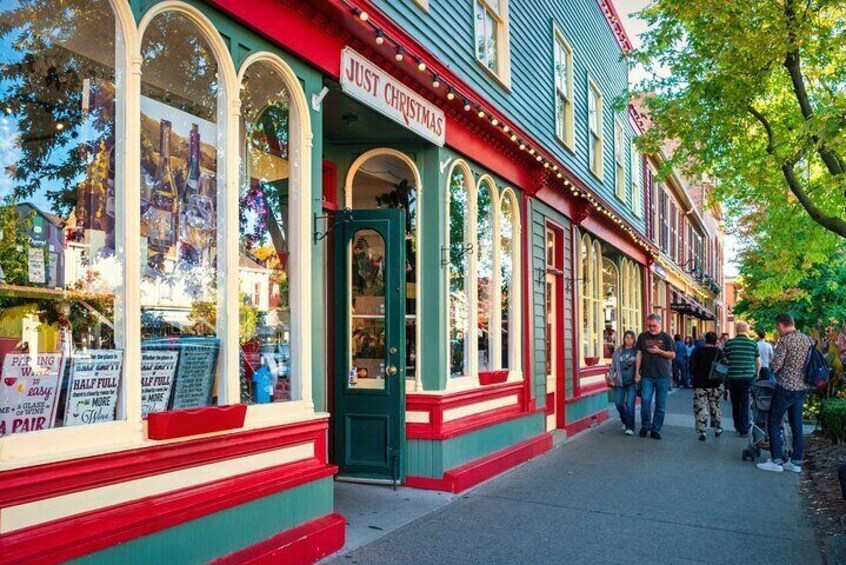 People walk past colorful stores in Niagara on the Lake, Ontario, Canada.