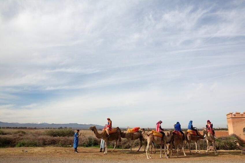 During a camel tour in the Atlas Mountains travelers wear traditional Berber head-covering and enjoy stunning views of Morocco’s countryside.