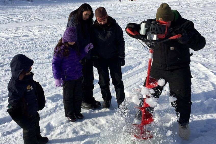 Drilling through ice to fish.