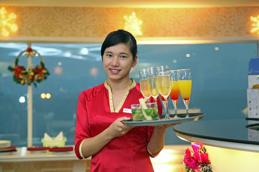 Serving holding a tray full of drinks on the Halong Bay dinner cruise