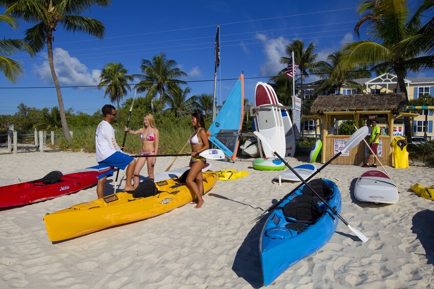 Group on the beach with kayaks and paddles in Miami