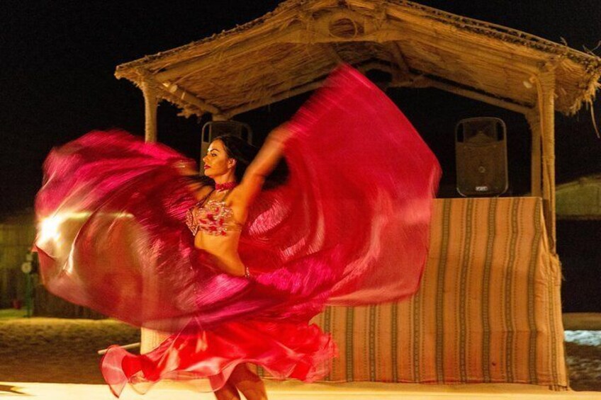 Belly dancer performs at a desert camp.