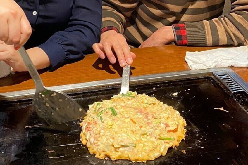 Attempting to flip an okonomiyaki pankcake
