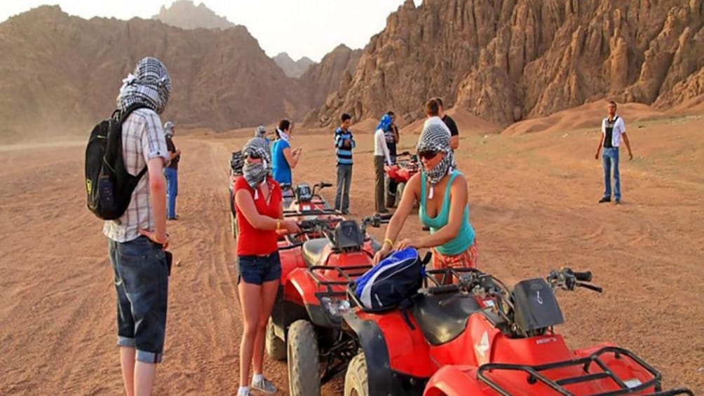 Tourists with headscarves prepare to ride quad bikes in Sinai Dessert