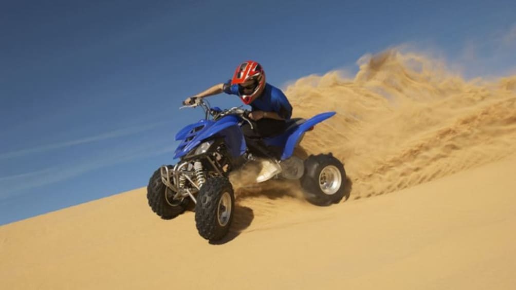 Man drives quad bike through the sand of Sinai Dessert