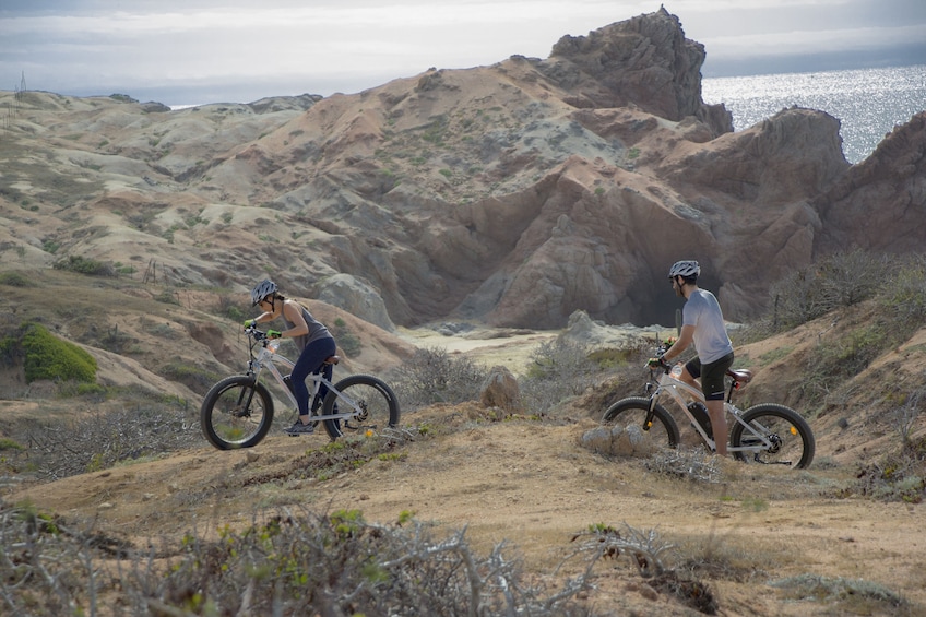 Two people electric bike through the mountains in Los Cabos