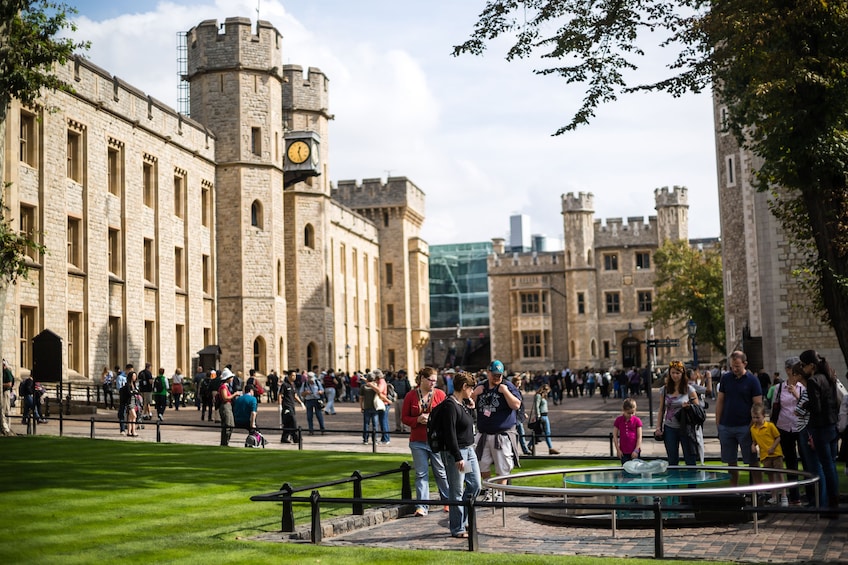 Tourists walk on the grounds of the Tower of London