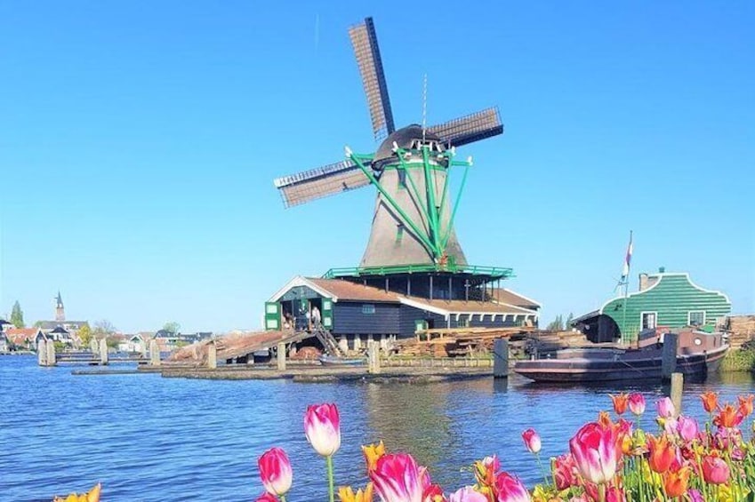 Flowers in bloom, water streaming and windmill catching wind.