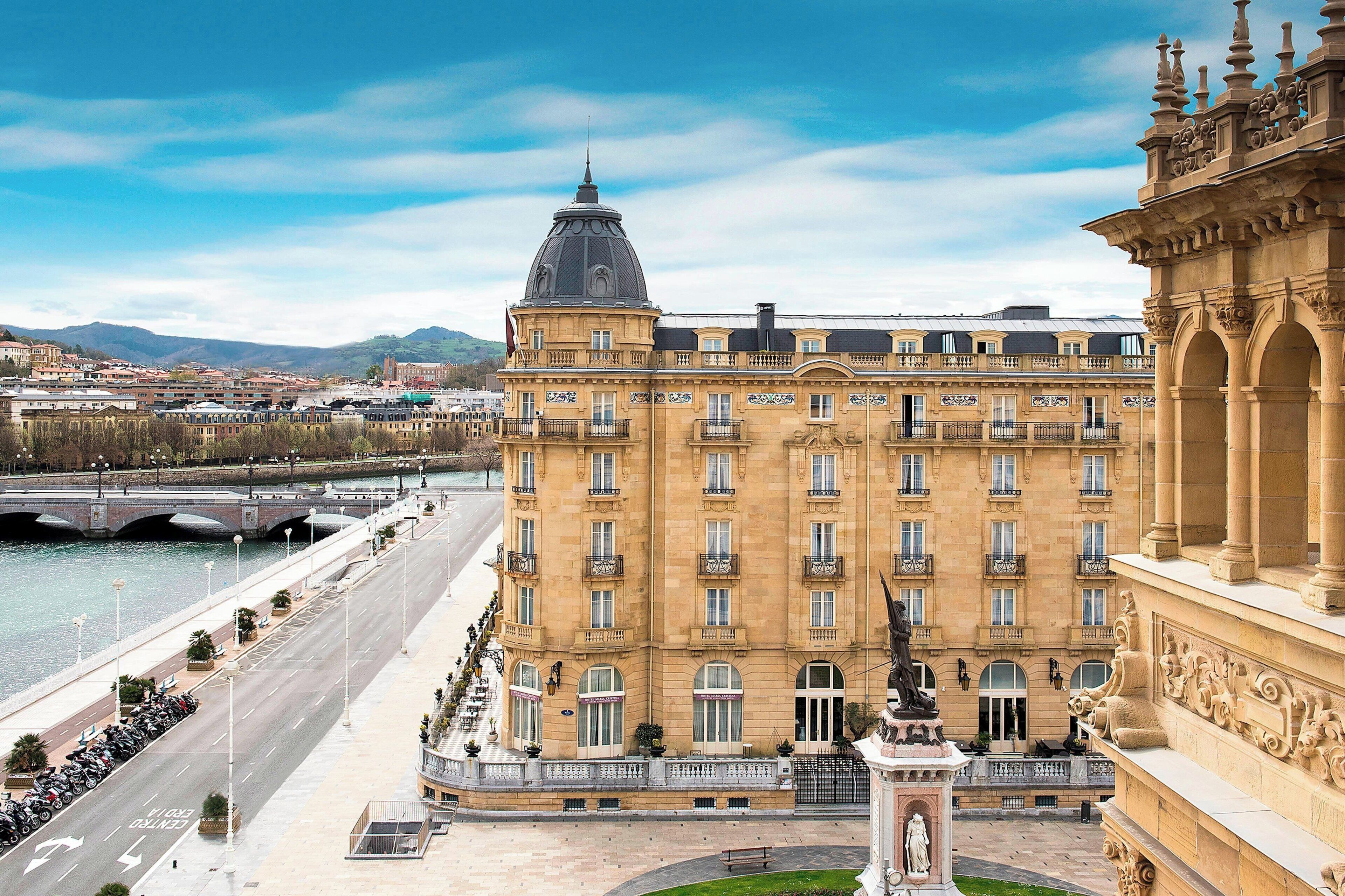 Eine luxuriöse Hotelhalle mit einem prächtigen Kronleuchter, stilvoller Sitzgelegenheiten und einem großen Gemälde an der Wand.