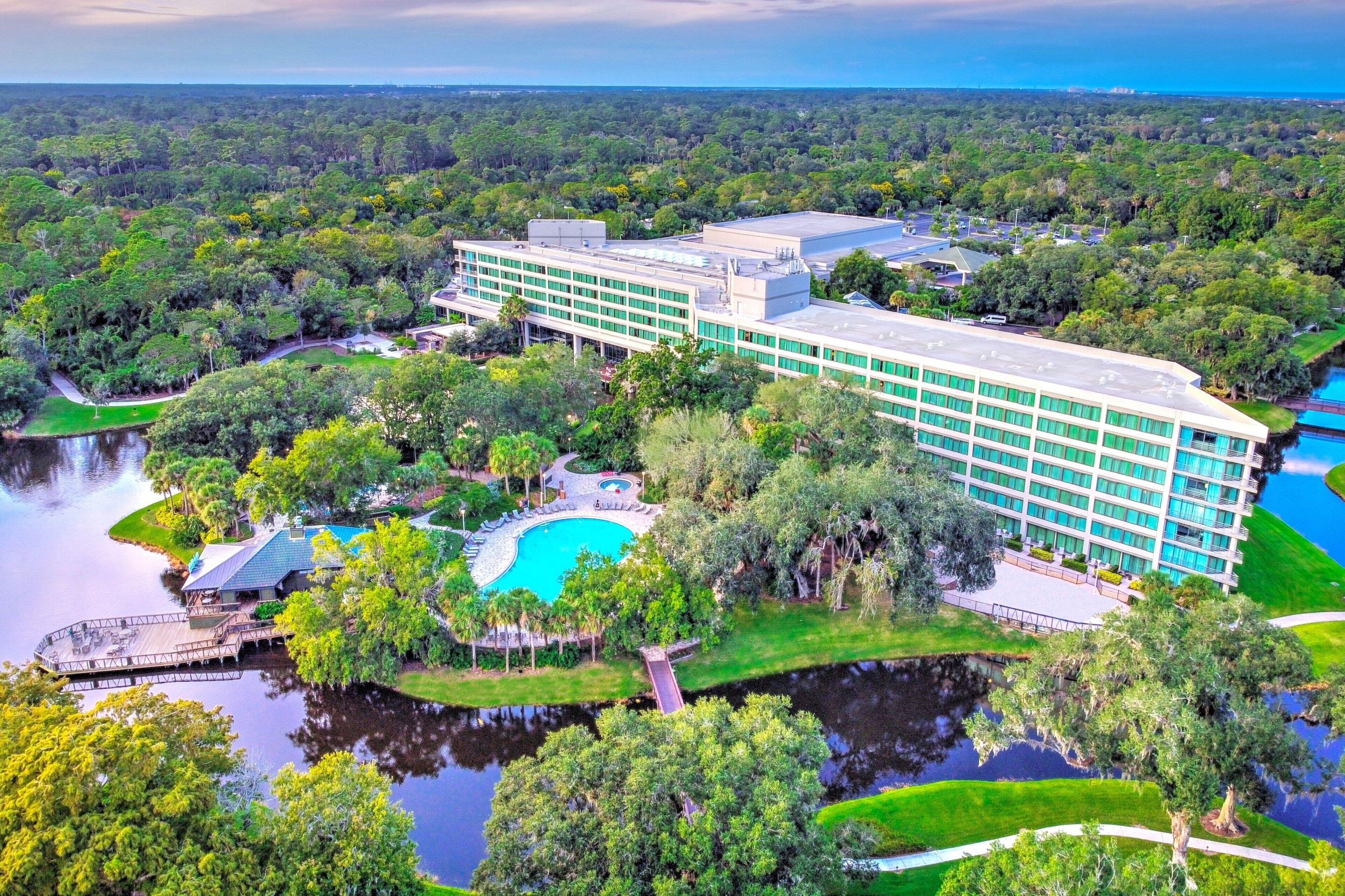 A resort with a swimming pool, beach view, and multiple buildings.