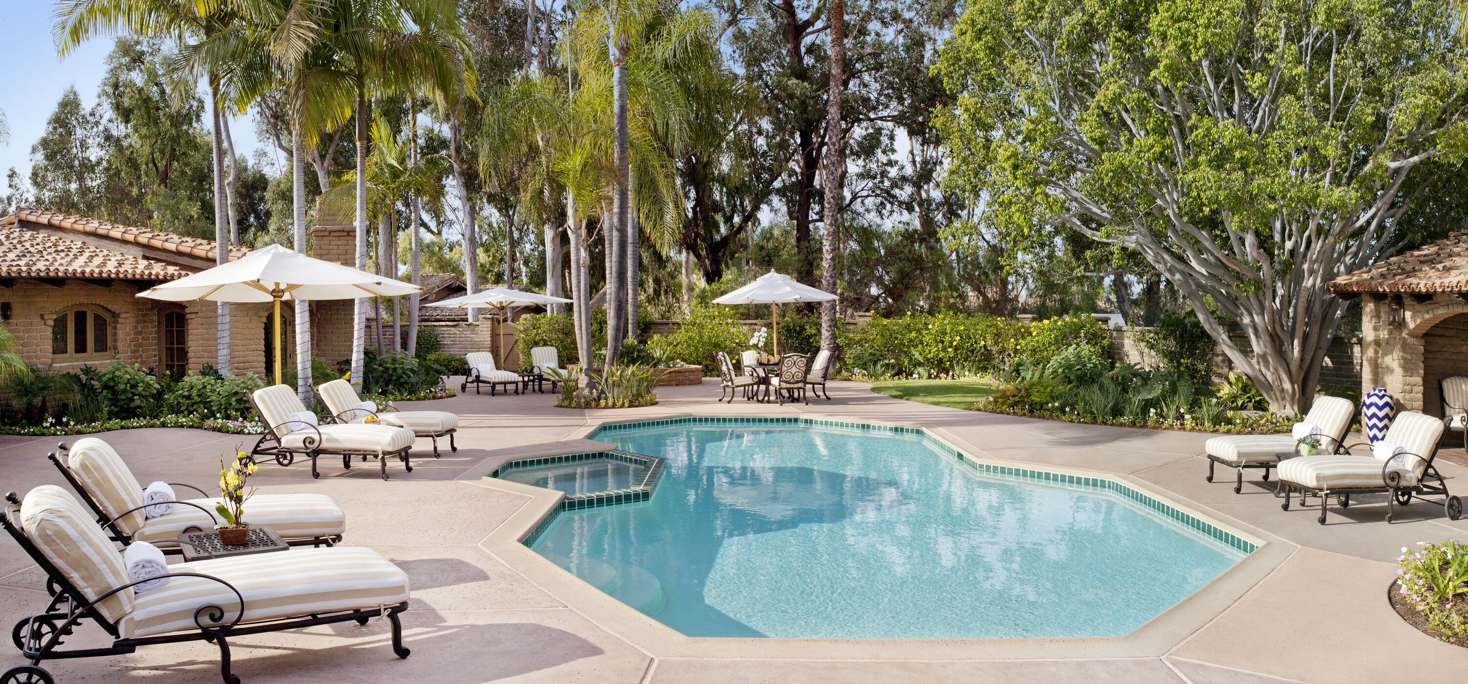 A modern resort with a swimming pool, a covered outdoor area, and a sunset view.