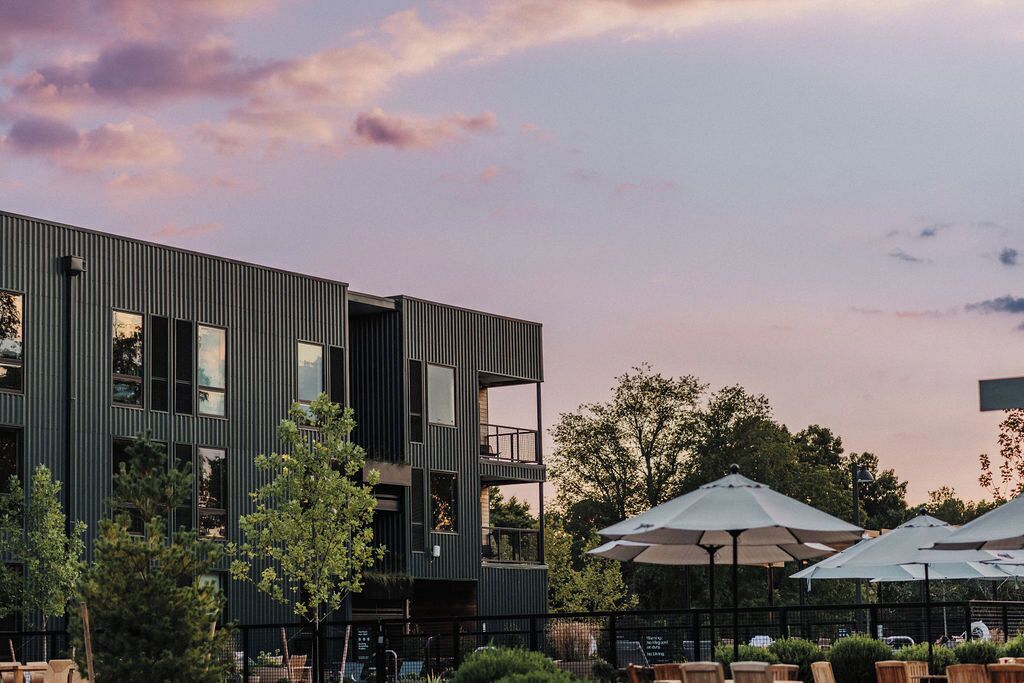 A modern building with a rooftop pool and outdoor seating area.