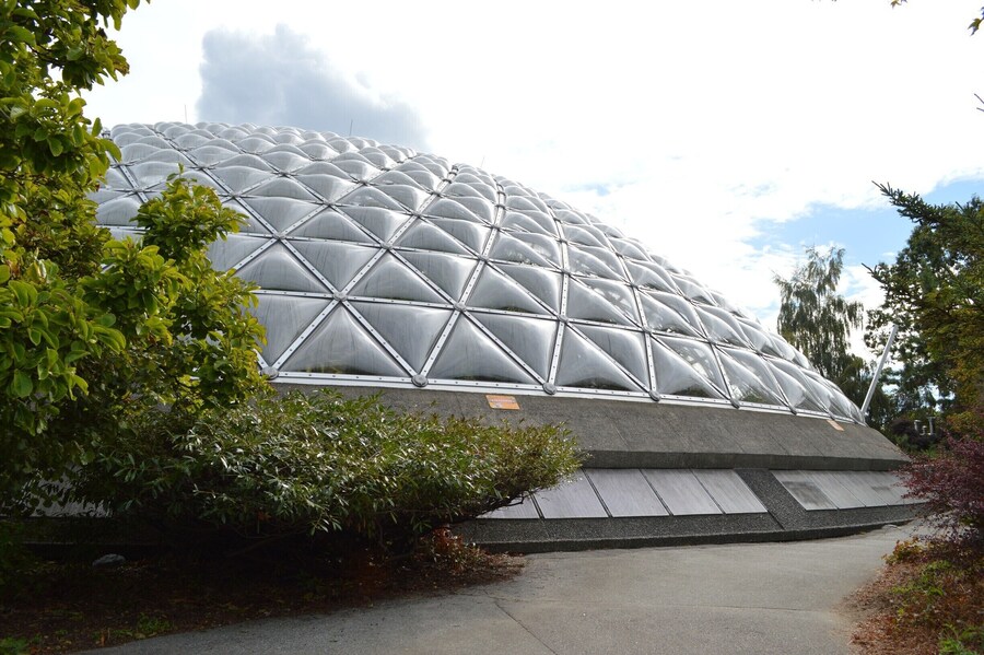 Exterior view of the domed Bloedel Conservatory surrounded by greenery in Vancouver.