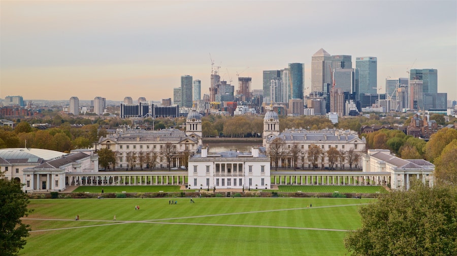 Panoramic view of Greenwich Park in London, featuring the Queen’s House and Old Royal Naval College in the foreground, with Canary Wharf’s modern skyline rising behind them.