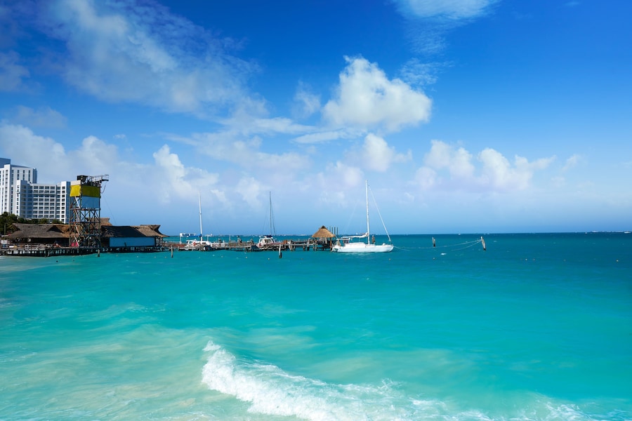 Turquoise waters and beach activities at Playa Tortugas in Cancun, Mexico.