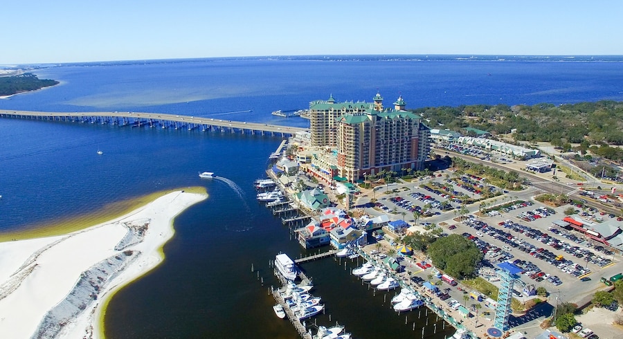 Aerial view of Destin Harbor Boardwalk with waterfront shops, boats, and scenic harbor in Destin, Florida.