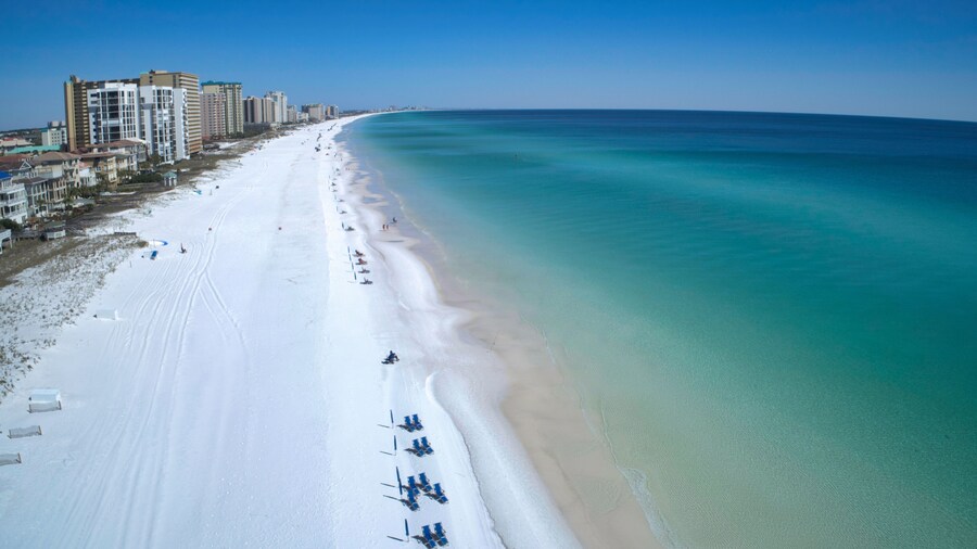 Aerial view of Jetty East Beach with white sand and calm Gulf waters in Destin, Florida.